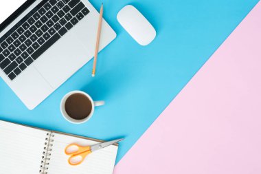 Yaratıcı düz Fotoğraf çalışma masası yatıyordu. Üstten görünüm ofis büro dizüstü, kalem, defter, kahve fincanı ve mavi pembe renkli arka plan üzerinde fare ile. Kopya alanı, düz yatıyordu fotoğraf ile üstten görünüm.