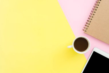 Ofis Masası adlı kullanıcının alanı - düz çalışma üstten görünüm fotoğraf çalışma alanı boş sahte tablet, kahve fincanı ve defter pastel zemin üzerine yatırın. Pastel pembe sarı renkli kopya alanı çalışma Resepsiyon kavramı.