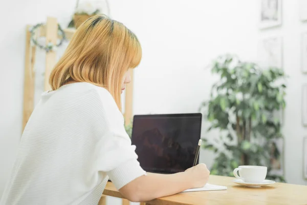 美丽的年轻微笑的亚洲妇女在笔记本电脑上工作 而坐在客厅在家里 在她家办公室工作的亚洲商界妇女 在家享受时光 — 图库照片