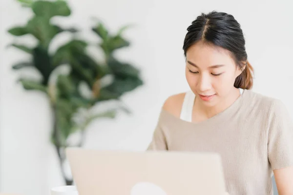 Kaunis Nuori Hymyilevä Aasialainen Nainen Työskentelee Kannettavan Tietokoneen Työpöydällä Olohuoneessa — kuvapankkivalokuva