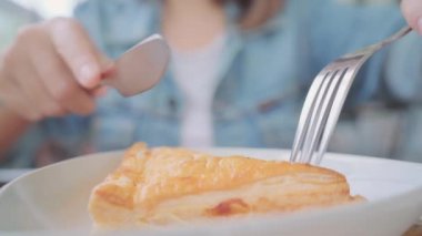 Ekmek yeme ve kafede masada otururken sıcak fincan kahve içme iş serbest Asyalı kadın. Yaşam tarzı akıllı güzel erkek rahat kafe kavramları.