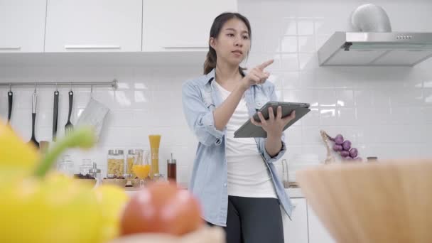 Mujer Asiática Feliz Usando Tableta Para Buscar Receta Mientras Que — Vídeo de stock