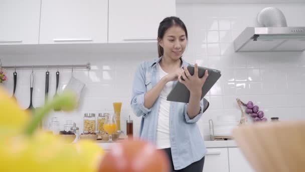 Mulher Asiática Feliz Usando Tablet Para Olhar Receita Fazer Comida — Vídeo de Stock