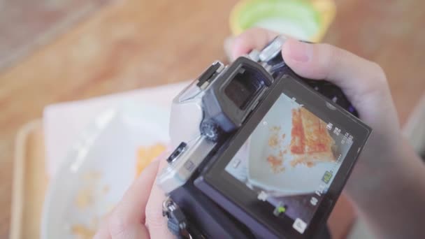 食物博主亚洲妇女使用相机拍照甜点 面包和饮料 而坐在咖啡馆的桌子上 生活方式美丽的女人放松在咖啡店的概念 — 图库视频影像