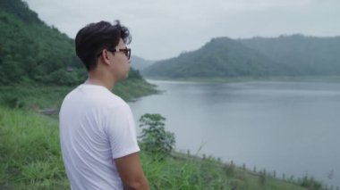 Uzun yürüyüşe çıkan kimse backpacker adamın macera hissi özgürlük yağmurlu günde göl yakınındaki ormanda yürüyüş hiking. Yaşam tarzı erkekler seyahat rahatla kavramı. 