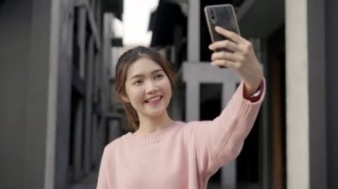 Beijing, Çin mahallesinde, seyahat ederken selfie alarak smartphone kullanan neşeli güzel genç Asyalı backpacker blogger kadın. Yaşam tarzı sırt çantası turizm seyahat tatil kavramı.