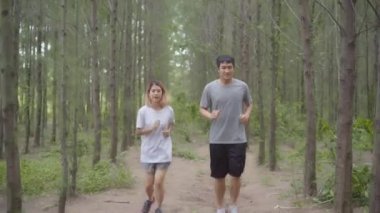 Sağlıklı genç atletik sportif Asya atlet erkek ve kadın giyim çalıştıran ve orman iz koşu spor. Yaşam tarzı uygun ve etkin kadınlar orman kavramında egzersiz.