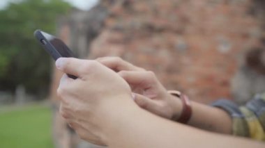 Seyahat Asya adam Smartphone ise sosyal medya Ayutthaya, Tayland tatil gezisi geçirdikten sonra dinlenmek, erkek zevk yolculuğu geleneksel şehirde inanılmaz Simgesel Yapı itibariyle kontrol kullanarak. 