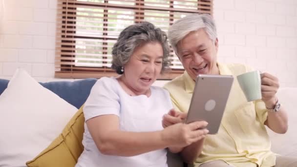 Asiatisches Älteres Paar Das Hause Tablette Nimmt Und Kaffee Trinkt — Stockvideo