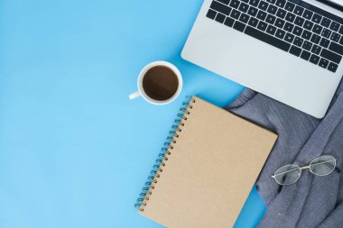 Ofis Resepsiyon çalışma alanı - düz üstten görünüm mockup bir çalışma alanı, dizüstü bilgisayar, Kırtasiye ve bir kahve fincanı eşarp ve mavi pastel zemin üzerine yatırın. Pastel mavi renk kopyalama alanı çalışma alanı kavramı