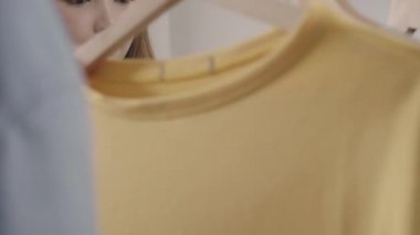 Evde dolap veya mağaza içinde onun moda kıyafet giysiler seçmek güzel çekici genç Asyalı kadın. Kız ne kazak giymeyi düşünüyorum. Ev dolap ya da soyunma giyim mağazası. 