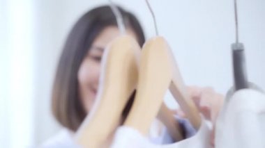 Evde dolap veya mağaza içinde onun moda kıyafet giysiler seçmek güzel çekici genç Asyalı kadın. Kız ne kazak giymeyi düşünüyorum. Ev dolap ya da soyunma giyim mağazası. 