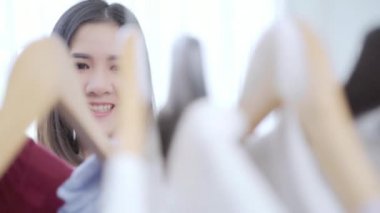 Evde dolap veya mağaza içinde onun moda kıyafet giysiler seçmek güzel çekici genç Asyalı kadın. Kız ne kazak giymeyi düşünüyorum. Ev dolap ya da soyunma giyim mağazası. 