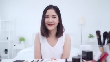 Güzellik blogger video kayıt için kamera önünde oturan güzellik kozmetik mevcut. Asyalı kadın kullanım kozmetik inceleme yapmak öğretici mutlu güzel genç sosyal ağ için canlı video yayını.