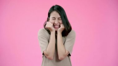 Olumlu ifade ile çok güzel Asyalı kadın gülümsüyor, gülümsüyor geniş, rahat giyim ve kameraya pembe arka plan üzerinde seyir giymiş. Mutlu çok güzel memnun kadın başarı sevinir.