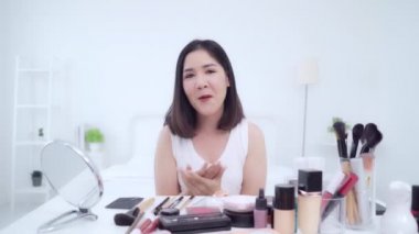 Güzellik blogger video kayıt için kamera önünde oturan güzellik kozmetik mevcut. Asyalı kadın kullanım kozmetik inceleme yapmak öğretici mutlu güzel genç sosyal ağ için canlı video yayını.