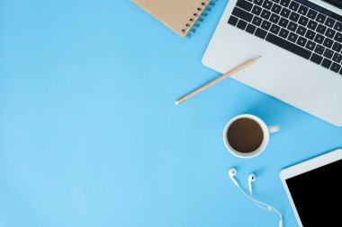 Ofis Masası adlı kullanıcının alanı - düz çalışma üstten görünüm mockup fotoğraf çalışma alanı dizüstü bilgisayar, akıllı aygıt ve bir fincan kahve pastel mavi zemin üzerine yatırın. Pastel mavi renk kopyalama alanı çalışma alanı kavramı.