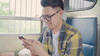 Sosyal medya bir tren çekerken kontrol smartphone kullanan Seyahat Asya adam genç erkek turist backpacker Tayland ona yolculuk keyfini çıkarın. Yaşam tarzları genç erkekler rahatla ve kavram seyahat.