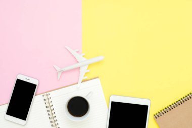 Tasarım seyahat yaz kavramının yat - boş defter, görünümünü alay akıllı telefon, tablet, uçak, kahve fincanı ve pembe sarı pastel renk uçakta kontör. Pastel renk arka plan üzerinde seyahat yaz.