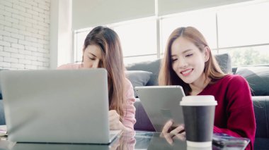 Lezbiyen Asyalı çift evde oturma odasında bütçe yapma dizüstü bilgisayar kullanarak, tatlı çift evde rahat zaman kanepede yatarken aşk anın tadını çıkarın. Yaşam tarzı çift evde kavramı relax.