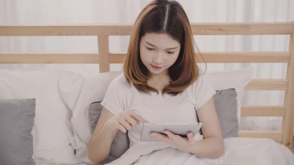 Nuori Aasialainen Nainen Joka Käyttää Tablettia Sängyssä Heräämisen Jälkeen Aamulla — kuvapankkivalokuva