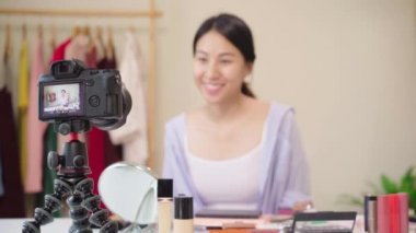 Güzellik blogger video kayıt için kamera önünde oturan güzellik kozmetik mevcut. Asyalı kadın kullanım kozmetik inceleme yapmak öğretici mutlu güzel genç sosyal ağ için canlı video yayını.