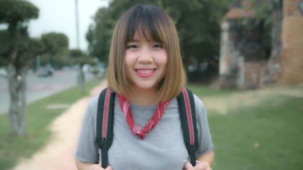 旅行アジア女性アユタヤ タイのバックパッカー女性をカメラ旅行に笑顔と幸せな気持ちでは 伝統的な都市の素晴らしいランドマークで彼の旅をお楽しみください ライフ スタイル旅行休日の概念 — ストック動画