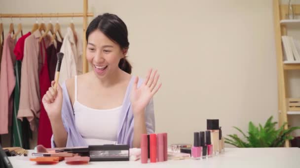 美容ブロガー プレゼント美容化粧品の前に座っては ビデオ録画のタブレットします 幸せな美しい若いアジア女性使用化粧品レビューは チュートリアルを構成するソーシャル ネットワークに放送します — ストック動画