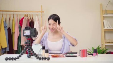 Güzellik blogger video kayıt için kamera önünde oturan güzellik kozmetik mevcut. Asyalı kadın kullanım kozmetik inceleme yapmak öğretici mutlu güzel genç sosyal ağ için canlı video yayını.