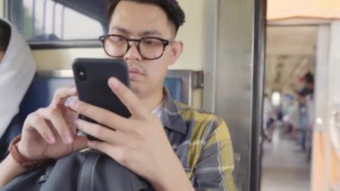 Sosyal medya bir tren çekerken kontrol smartphone kullanan Seyahat Asya adam genç erkek turist backpacker Tayland ona yolculuk keyfini çıkarın. Yaşam tarzları genç erkekler rahatla ve kavram seyahat.