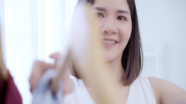 Evde dolap veya mağaza içinde onun moda kıyafet giysiler seçmek güzel çekici genç Asyalı kadın. Kız ne kazak giymeyi düşünüyorum. Ev dolap ya da soyunma giyim mağazası. 