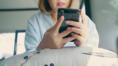 Kafede masada otururken konuşma, okuma ve manifatura için Smartphone kullanarak iş serbest Asyalı kadın. Kahve dükkanı concepts çalışma yaşam tarzı zeki güzel kadınlar.