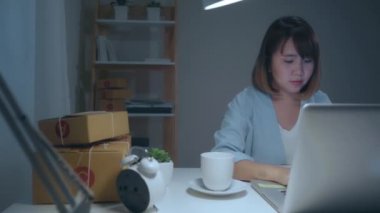 Güzel akıllı Asya genç girişimci iş kadın sahibi KOBİ online ürün stok kontrol ve gece eve geç çalışan bilgisayara kaydedin. Küçük işletme sahibi, ev ofis kavramı.