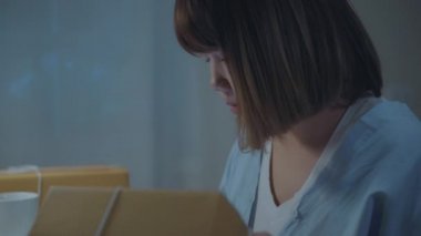 Güzel akıllı Asya genç girişimci iş kadın sahibi KOBİ online ürün stok kontrol ve gece eve geç çalışma tablet kaydedin. Küçük işletme sahibi, ev ofis kavramı.