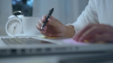 Genç Asyalı kadın evde oturma odasında masada laptop kullanarak geç çalışma. Asya iş kadını ev ofisinde gece defter belge finans ve hesap yazma. Evde zaman zevk konsepti.