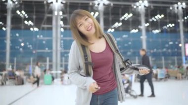 Yavaş hareket - Uluslararası Havaalanı Kalkış kapısında yatılı uçuşa giderken terminal salonunda yürüyen genç Asyalı backpacker kadın. Yaşam tarzı sırt çantası turizm seyahat tatil kavramı.