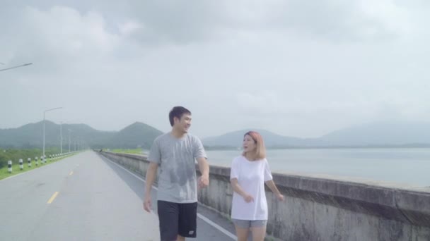 亚洲跑步者夫妇的腿温暖和伸展她的手臂 准备在街上跑步 健康的年轻甜夫妇在湖边锻炼 生活方式适合和积极的夫妇锻炼街头概念 — 图库视频影像