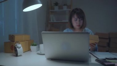 Güzel akıllı Asya genç girişimci iş kadın sahibi KOBİ online ürün stok kontrol ve gece eve geç çalışan bilgisayara kaydedin. Küçük işletme sahibi, ev ofis kavramı.