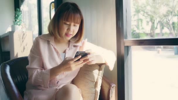 商务自由的亚洲女性妇女使用智能手机说话 阅读和发短信 而坐在桌子上的咖啡馆 生活方式聪明的美女在咖啡店工作的概念 — 图库视频影像