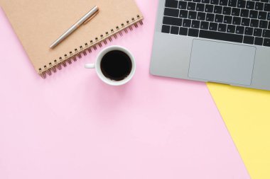 Yaratıcı düz fotoğraf çalışma masası yatıyordu. Üstten Görünüm ofis büro dizüstü bilgisayar, boş boş defter ve kahve fincanı pastel renk arka plan üzerinde. Kopya alanı, düz yatıyordu fotoğraf ile Üstten Görünüm.