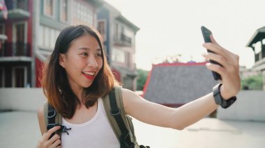 Beijing, Çin mahallesinde, seyahat ederken selfie alarak smartphone kullanan neşeli güzel genç Asyalı backpacker blogger kadın. Yaşam tarzı sırt çantası turizm seyahat tatil kavramı.