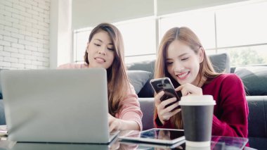 Lezbiyen Asyalı çift evde oturma odasında bütçe yapma dizüstü bilgisayar kullanarak, tatlı çift evde rahat zaman kanepede yatarken aşk anın tadını çıkarın. Yaşam tarzı çift evde kavramı relax.