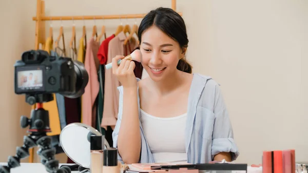 Skjønnhetsblogger presenterer skjønnhetskosmetikk foran kamera for opptak av video. Vakker asiatisk kvinne bruker kosmetikk til å lage en veiledende kringkastingsvideo til sosiale nettverk via Internett . – stockfoto