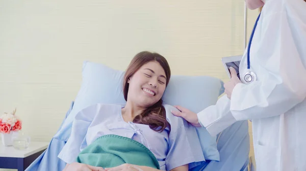 Jovem mulher médica asiática falando e segurando a mão para as mulheres paciente na cama doente. Medicina, idade, saúde, psiquiatra e conceito de pessoas . — Fotografia de Stock