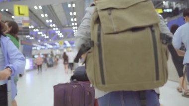 Yavaş hareket - Uluslararası Havaalanı Kalkış kapısında yatılı uçuşa giderken terminal salonunda yürüyen genç Asyalı backpacker kadın. Yaşam tarzı sırt çantası turizm seyahat tatil kavramı.