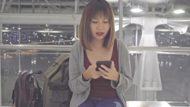 Kullanarak Onun Smartphone Uçağının Kalkış Kapısı Uluslararası Havaalanında Beklerken Terminal — Stok video