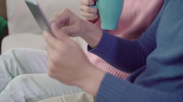Jovem Casal Asiático Usando Tablet Beber Café Sala Estar Casa — Vídeo de Stock