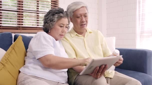 Asiatiska Äldre Par Använda Tablett Sök Medicin Information Vardagsrummet Par — Stockvideo
