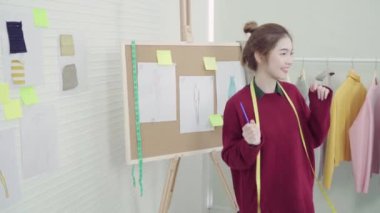 Profesyonel güzel Asyalı kadın moda kumaş çizimler ile çalışma ve stüdyoda giyim tasarım çizim tasarımcı. Yaşam tarzı kadın kavramı çalışma.