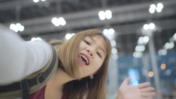 スロー モーション ビデオを作るビデオブログ 飛行を待っている間国際空港のターミナルのホールに立っている女性のカメラを使用して若いアジア バックパッカー ブロガー女性 ライフ スタイルの女性の旅行の概念 — ストック動画